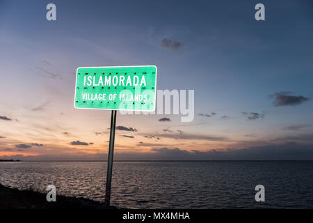 Lever du soleil à Islamorada, Florida Keys, avec ciel bleu, orange beach, panneau vert libre, village des îles, dans l'océan Atlantique, golfe du Mexique, horizon Banque D'Images