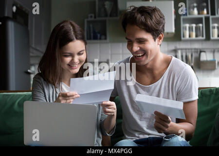 Happy young couple excité par la lecture de bonnes nouvelles dans la lettre Banque D'Images