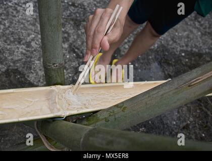 Attraper un fluide tout en mangeant des nouilles nagashi traditionnels (découlant de la Suomen nouilles) à Kyushu, au Japon Banque D'Images