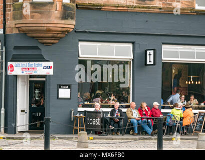 Leith Jazz & Blues Festival de musique live dans les restaurants et bars par l'eau de Leith, 3e juin 2018. La Rive, Leith, Edinburgh, Ecosse, Royaume-Uni. Le Jazz and Blues Festival se déroule sur 3 jours de semaine. Les gens envahissent la chaussée extérieure tables des restaurants et bars au bord de l'eau de Leith bénéficiant d'écouter de la musique en direct gratuit. Les gens au bar à vin et restaurant, le toast avec le festival affiche bannière Banque D'Images