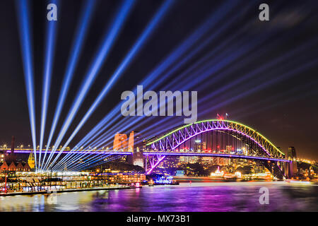 Vivid sydney festival de lumière et d'idées dans la ville de Sydney CBD autour de Port avec les faisceaux lumineux sur le Harbour Bridge à partir de Circular Quay. Banque D'Images