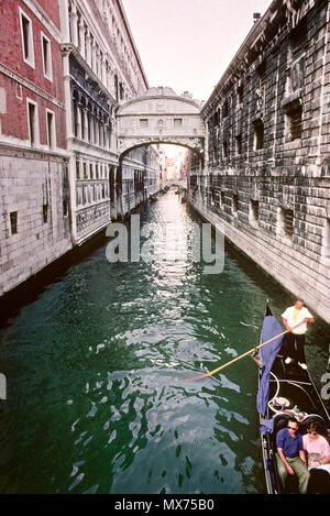 Une télécabine passe sous le Pont des Soupirs que arches sur un canal derrière le Palais des Doges à Venise, Italie. Banque D'Images