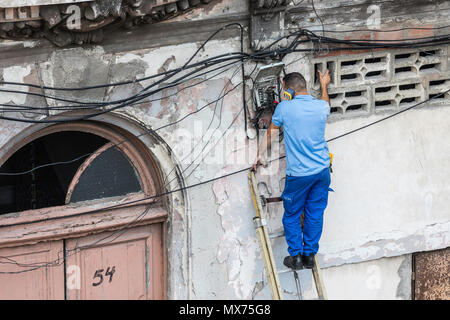La fixation d'un travailleur de lignes téléphoniques dans la vieille Havane, Cuba Banque D'Images