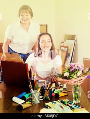 Jeune femme peint un tableau sous les conseils de son professeur Banque D'Images