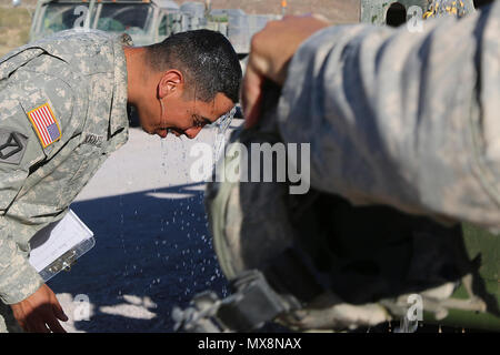 L'Adjudant-chef 3 Carlos Morales, un surveillant de l'entretien avec la 110e compagnie de maintenance Support, Massachusetts Army National Guard, vous permet un flux d'eau d'un buffle d'eau verser sur sa tête à Fort Irwin, en Californie le 3 mai 2017. Au cours d'une rotation de trois semaines au Centre National d'entraînement, les soldats de la 110ème ont été appelé pour un accident impliquant un buffle qui a dû être vidé afin de récupérer le véhicule c'était attaché. Sur un jour de près de 100 degrés dans le désert de Mojave, ont profité de cette et utilisé l'eau de refroidir en buvant de la st Banque D'Images