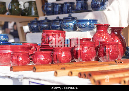 Tasses en céramique et de casseroles, sifflets en bois, instruments de musique en bois, de la rue du marché, des biens affichés sur la table. Banque D'Images