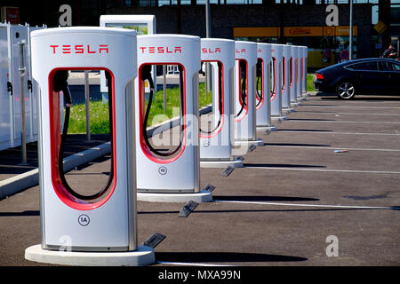 Tesla voiture électrique multi points de charge à la station service en français Banque D'Images