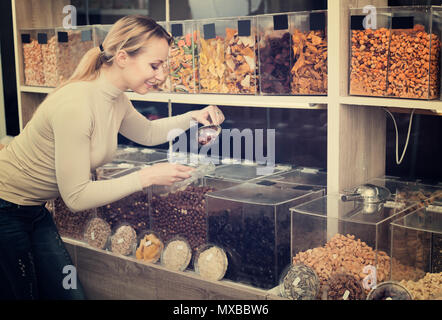 La sélection de la clientèle féminine adulte divers écrous dans le magasin avec produits écologiques Banque D'Images