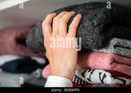 Femme est de sortir le chiffon d'hiver hors de l'armoire. Banque D'Images