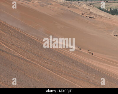 Camel cavaliers dans la Montagne de Feu, Turpan, Xinjiang, Chine Banque D'Images