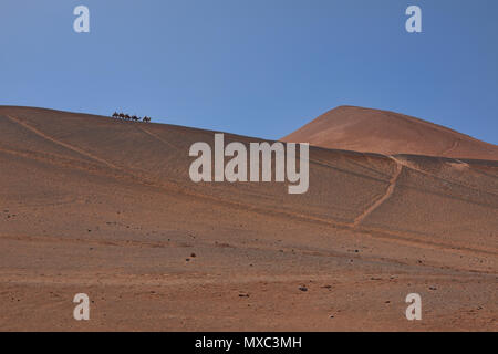 Camel cavaliers dans la Montagne de Feu, Turpan, Xinjiang, Chine Banque D'Images