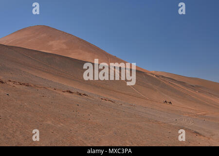 Camel cavaliers dans la Montagne de Feu, Turpan, Xinjiang, Chine Banque D'Images