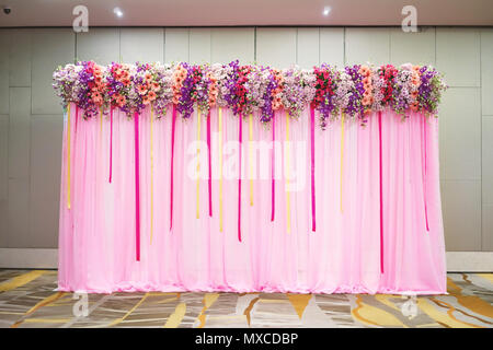 La belle toile de tissu rose avec décoration avec différentes couleurs de fleur et ruban pour la réception de mariage Banque D'Images