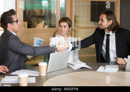 Businessman handshaking nouveau collègue au cours de la réunion de l'équipe Banque D'Images