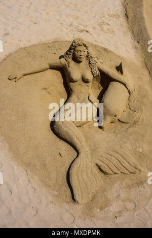 Sculpture de sable à Guardamar del Segura sur la plage méditerranéenne. Sirène avec dauphin Banque D'Images
