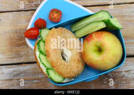 École en santé le déjeuner composé de bagel au fromage à la crème, de concombre et de pomme Banque D'Images