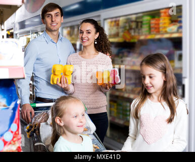 Les parents de deux filles d'acheter le yogourt aux fruits et au lait Banque D'Images