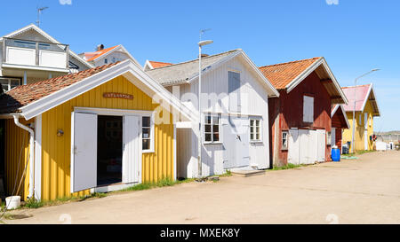 Grundsund, Suède - le 19 mai 2018 : Voyage documentaire de la vie quotidienne et le lieu. Les petites cabanes dans le port avec des maisons en arrière-plan. Banque D'Images
