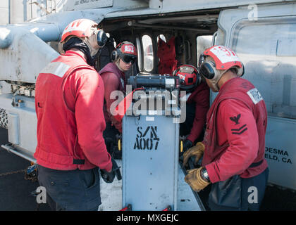 Les marins affectés à la "Golden Falcon" de la mer d'hélicoptères de l'Escadron de Combat (HSC) 12 Chargement d'un 20 mm munitions peut dans un Sea Hawk MH-60S dans le poste de pilotage de la Marine est qu'avant-déployé, porte-avions USS Ronald Reagan (CVN 76). L'hélicoptère Sea Hawk est équipé d'une mitrailleuse M197 que les incendies d'aéronefs de 20 mm. C'est Ronald Reagan qui participent à l'exercice Keen Sword 17 (KS17), une biennale, chef d'état-major interarmées-dirigé, AMÉRICAINES DU PACIFIQUE-parrainé la formation sur le terrain de l'exercice. KS17 est conçu pour répondre aux objectifs de défense mutuelle en augmentant la préparation au combat et je Banque D'Images