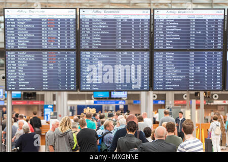 04 juin 2018, Hambourg, Allemagne : les voyageurs font la queue à l'Helmut-Schmidt-aéroport en vertu de l'écran avec le calendrier. Après une coupure de courant, le dimanche, les opérations de vol le lundi matin a été repris, mais il y a toujours des retards. Photo : Daniel Bockwoldt/dpa Banque D'Images