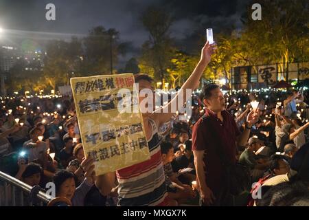 Hong Kong, Hong Kong. 4 juin, 2018. Un jeune homme vu holding a placard et tenant une bougie pendant la veillée service.Des centaines de milliers de personnes ont assisté à Hong Kong le service annuel veillée aux chandelles dans le parc Victoria, dans le centre de Hong Kong pour ceux qui ont perdu la vie durant le massacre de la place Tiananmen en 1989 à Pékin où l'Armée de libération du peuple chinois assassiné des centaines de manifestants pro démocratie.Les personnes qui ont pris part à l'événement demandez à exiger la démocratie du gouvernement central chinois et appellent à la fin de la décision d'une partie du système. (Crédit Image : © Geovien Si/SOP Banque D'Images