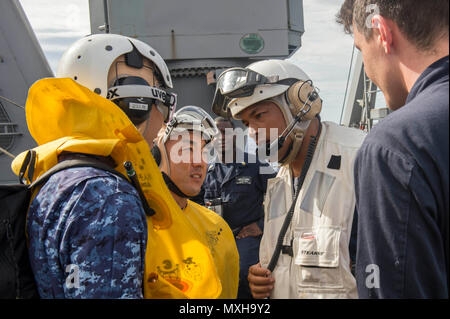 Océan Pacifique (nov. 6, 2016). Gervy Alota, commandant du navire de débarquement quai amphibie USS Comstock (LSD 45) accueille le lieutenant J.G. Shogo Kudo, à gauche, et le Maître de 2e classe Kazuhiko Iwanatsu, centre, en s'engageant dans l'épée 17 pour les amateurs de Comstock. Keen Sword 17 est une initiative conjointe de l'exercice de formation sur le terrain et bilatérales (FTX) entre les États-Unis et les forces japonaises destinées à accroître la préparation opérationnelle et l'interopérabilité dans le cadre de l'alliance américano-japonaise. (U.S. Photo de la marine par le maître de 3e classe Abby Rader/libérés) Banque D'Images