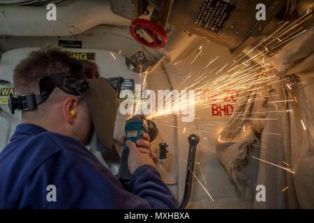 161104-N-DQ503-355 MER ROUGE (nov. 4, 2016) Maître de 3e classe Sean Stillwell utilise une meuleuse sur une porte étanche pour préparer une surface de soudure à bord du destroyer lance-missiles USS Roosevelt (DDG 80). Roosevelt, déployés dans le cadre du groupe aéronaval d'Eisenhower, appuie les opérations de sécurité maritime et les efforts de coopération en matière de sécurité dans le théâtre dans la 5e flotte américaine zone d'opérations. (U.S. Photo de la marine par le maître de 3e classe Taylor A. Elberg) Banque D'Images