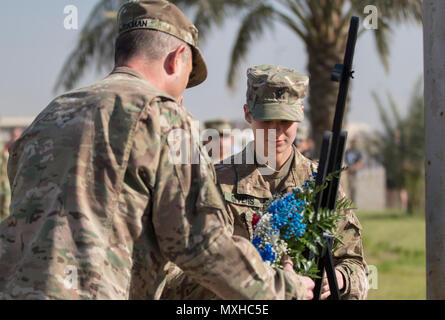 Le général de l'armée William Hickman, U.S. Army's Central commandant général adjoint - opérations, et de la CPS. Larissa Givens, un des plus jeunes anciens combattants au Camp Arifjan, au Koweït, déposer une couronne au cours d'une cérémonie en l'honneur des anciens combattants militaires le 11 novembre 2016. La cérémonie comprenait également des chants et des poèmes par des soldats en célébration de la Journée des anciens combattants. (U.S. Photo de l'armée par le Sgt. Angela Lorden) Banque D'Images