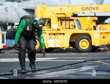 SN Michael Dennis, de Zagreb, Géorgie, vérifie l'arrêtant sur le fil pendant les opérations de vol dans le poste de pilotage de la Marine est qu'avant-déployé, porte-avions USS Ronald Reagan (CVN 76). Au cours des opérations de valorisation, d'avions atterrir en toute sécurité sur le pont à l'aide d'un des trois fils d'arrêter de ralentir l'avion sur le poste de pilotage. Ronald Reagan, le groupe aéronaval du cinq (5) CSG, phare est en patrouille soutenir la sécurité et la stabilité dans la région du Pacifique-Indo-Asia. (U.S. Photo par MARINE MATELOT Jamaal Liddell/libérés) Banque D'Images