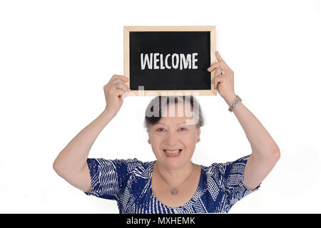 Femme âgée holding tableau avec le texte "bienvenue" dans ses mains. Isolé sur fond blanc Banque D'Images