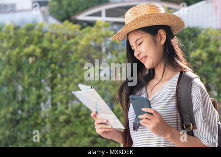 Asian woman traveler backpacker utilisez la carte et téléphone mobile app pour rechercher l'emplacement de la route avec le GPS sur place dans la rue où les voyages en ville, Technolog Banque D'Images