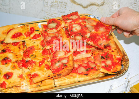 Tranches de pizza apéritif avec cueillette à la main. Isolé sur un tableau blanc. Banque D'Images
