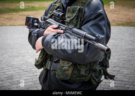 Un homme avec une mitraillette. homme mains d'homme tenant un fusil. Les troupes irrégulières. unprofessional militaires. Milicien. Fusil d'assaut Kalachnikov avec lase Banque D'Images