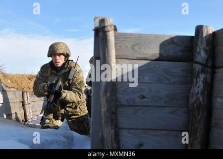 Un soldat du 1er Bataillon, 80e brigade aéromobile efface une tranchée au cours d'un tir de suppression d'entraînement dirigé par des soldats affectés au 6e Escadron, 8e régiment de cavalerie, d'infanterie 2e Brigade Combat Team, 3e Division d'infanterie, à l'internationales de maintien de la paix et à la sécurité, le 18 novembre 2016. Cette formation est l'une des tâches collectives que le bataillon ukrainien doit accomplir au cours de leurs 55 jours de rotation avec le Group-Ukraine multinational interarmées. La formation est conçue pour renforcer les compétences défensives de l'Armée de terre afin d'augmenter leurs capacités Banque D'Images