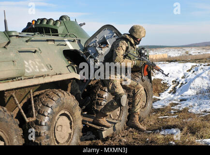 Un soldat du 1er Bataillon, 80e brigade aéromobile saute hors d'un véhicule blindé BTR lors d'un tir de suppression d'entraînement dirigé par des soldats américains affectés au 6e Escadron, 8e régiment de cavalerie, d'infanterie 2e Brigade Combat Team, 3e Division d'infanterie, à l'internationales de maintien de la paix et à la sécurité, le 18 novembre 2016. Cette formation est l'une des tâches collectives que le bataillon ukrainien doit accomplir au cours de leurs 55 jours de rotation avec le Group-Ukraine multinational interarmées. La formation est conçue pour renforcer les compétences défensives de l'Armée de terre de l'Ukraine Banque D'Images