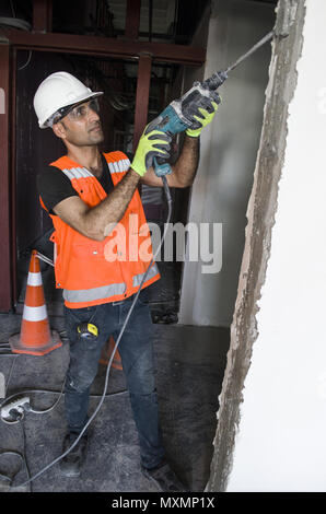 Hadyman à l'aide d'un marteau perforateur à béton distroy murs intérieurs Banque D'Images