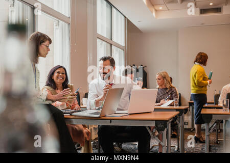 Co-workers talking et discussion de l'information ordinateurs portables. Avoir une réunion au cours d'un déjeuner de la conférence d'affaires. Banque D'Images