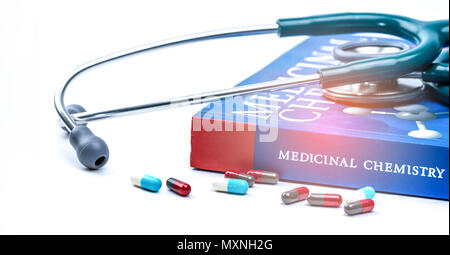 Stéthoscope mis sur manuel de chimie médicinale et des pilules sur capsule de table blanc médecin. La structure de recherche de drogues concept. Coeur de la cardiologie et de l'h Banque D'Images