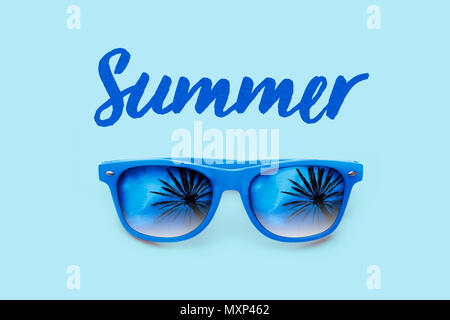 Texte bleu texturé d'été bleu et lunettes de soleil avec palmiers réflexions isolées dans un fond bleu clair. Concept minimaliste pour l'été, le soleil chaud Banque D'Images