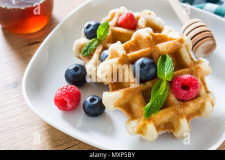 Gaufres Belges traditionnelles avec les bleuets et framboises sur table en bois Banque D'Images