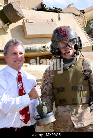 La FPC. Jon certificat, une armure d'équipage avec l'entreprise C, 3e Bataillon, 69e régiment de blindés, présente le bouchon arrière d'un réservoir de 120mm round au membre du Congrès Earl "Buddy" Carter, le représentant américain de la Géorgie au service 1er arrondissement. La Pac a été l'arrière du réservoir round Carter tiré par un M1A2 Abrams char de combat principal lors de sa visite à Fort Stewart, en Géorgie le 30 novembre. (U.S. Photo de l'armée par le Major Randy prêt) Banque D'Images