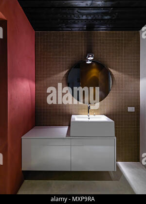 Salle de bains moderne l'intérieur à l'avant-plan le livre blanc du cabinet lavabo lavabo de comptoir avec le mur est recouvert de carreaux de mosaïque Banque D'Images