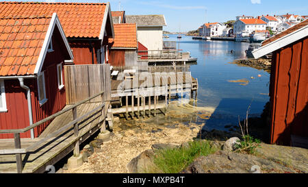 Grundsund, Suède - le 19 mai 2018 : Voyage documentaire de la vie quotidienne et le lieu. Baie étroite avec des cabines en bois rouge. Le village et le détroit avec des bateaux Banque D'Images
