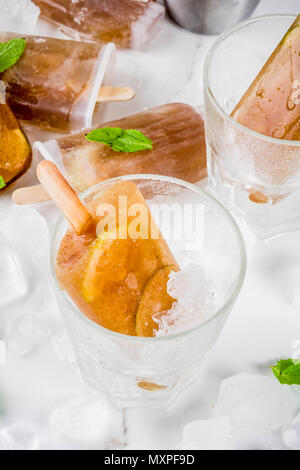 Les boissons rafraîchissantes, cocktails d'été recette sucettes glacées, cuba libre, thé ou café sucré froid, avec de la glace, de lime et de feuilles de menthe sur le marbre blanc backg Banque D'Images