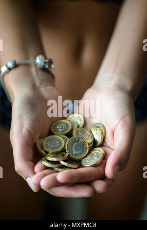 Mains pleines avec UK Pound Coins Banque D'Images