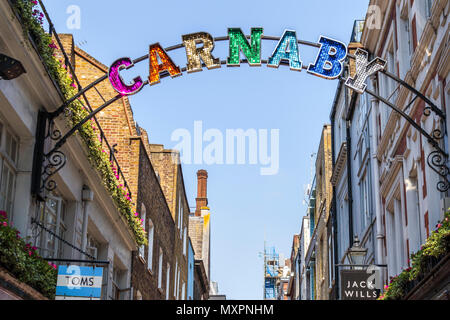 Inscrivez-colorées brillantes à l'entrée de la célèbre Carnaby Street dans le West End Carnaby quartier commercial, Soho, London W1 sur une journée ensoleillée Banque D'Images