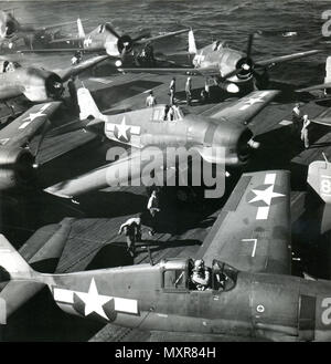 27 octobre 1944 - PILOTES MAN VOS PLANS - des pilotes de la marine attendent dans leur Grumman HELLCATS à bord du USS Bunker Hill d'après l'ordre 'Pilotes' homme vos plans pour une attaque contre les Japonais. Banque D'Images