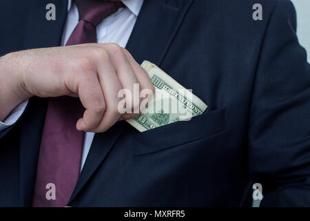 Un homme d'affaires affiche une somme d'argent, le met dans sa poche de costume Banque D'Images
