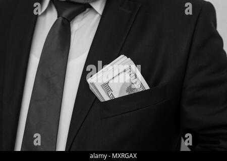 Un homme d'affaires affiche une somme d'argent, le met dans sa poche de costume Banque D'Images