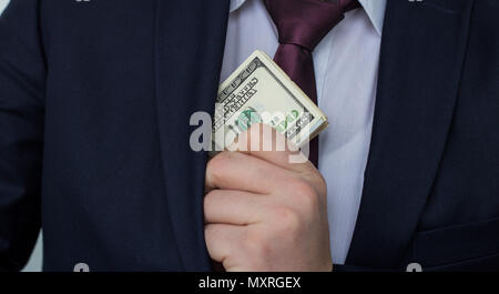 Un homme d'affaires affiche une somme d'argent, le met dans sa poche de costume Banque D'Images